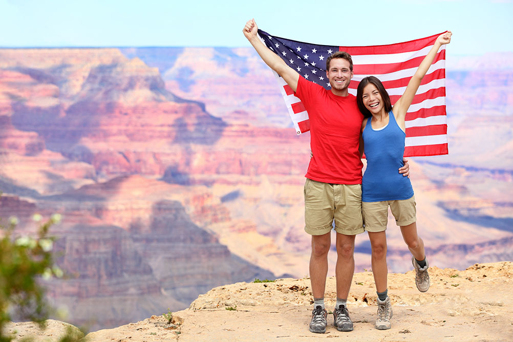 PowerBall: World's Biggest Lottery Jackpot Couple wave American flag at Grand Canyon to celebrate the Powerball record jackpot