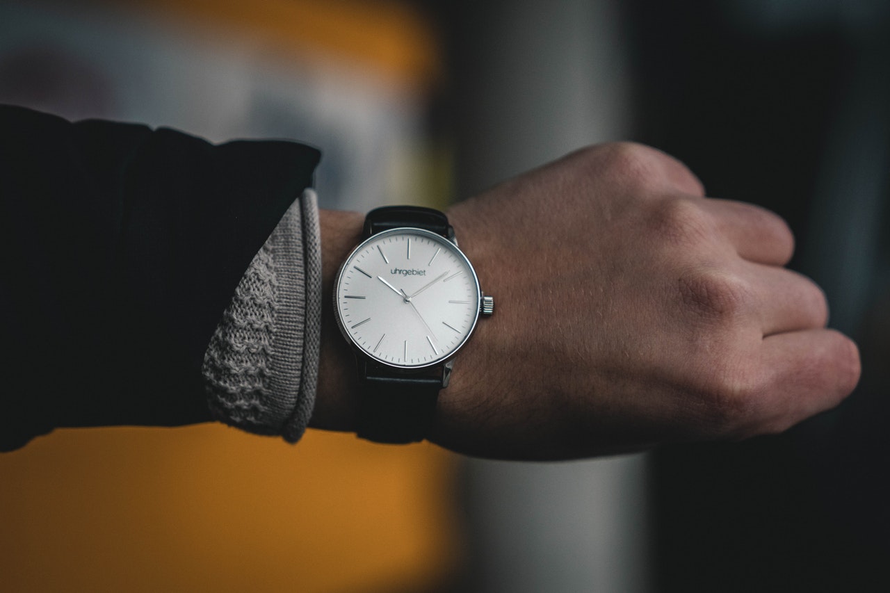 How Long Does a Powerball Payout Take? The arm of a man as he looks at his watch