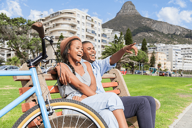 Couple sitting on bench in Cape Town pointing finger
