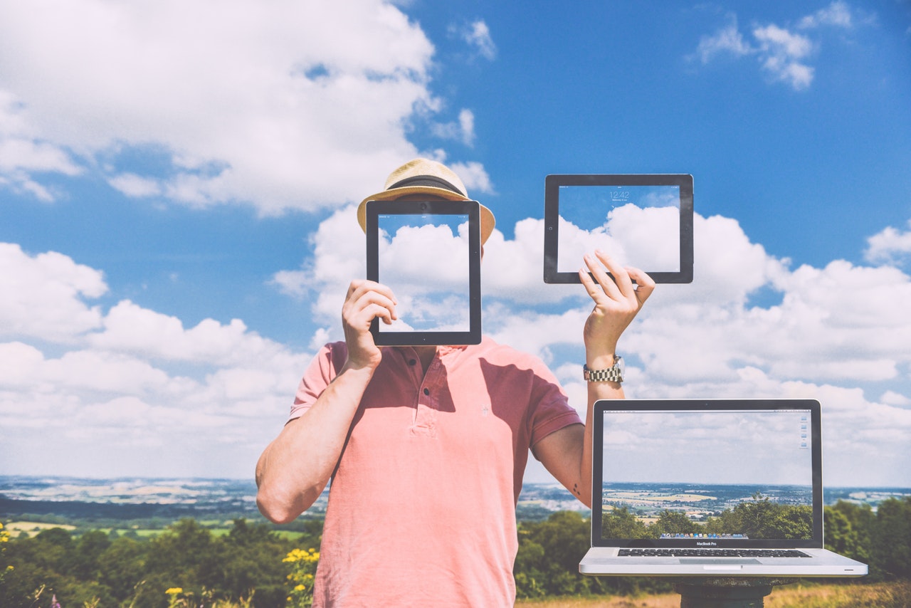 Man hides behind a tablet screen held in front of his face